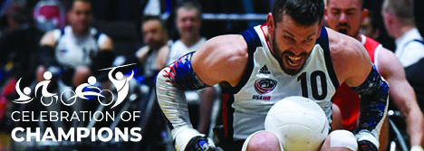 A wheelchair rugby athlete wearing a white jersey with navy accents and the USA Wheelchair Rugby logo.